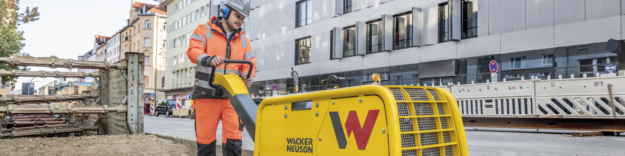 A Wacker Neuson vibratory plate in action on a construction site in the city.