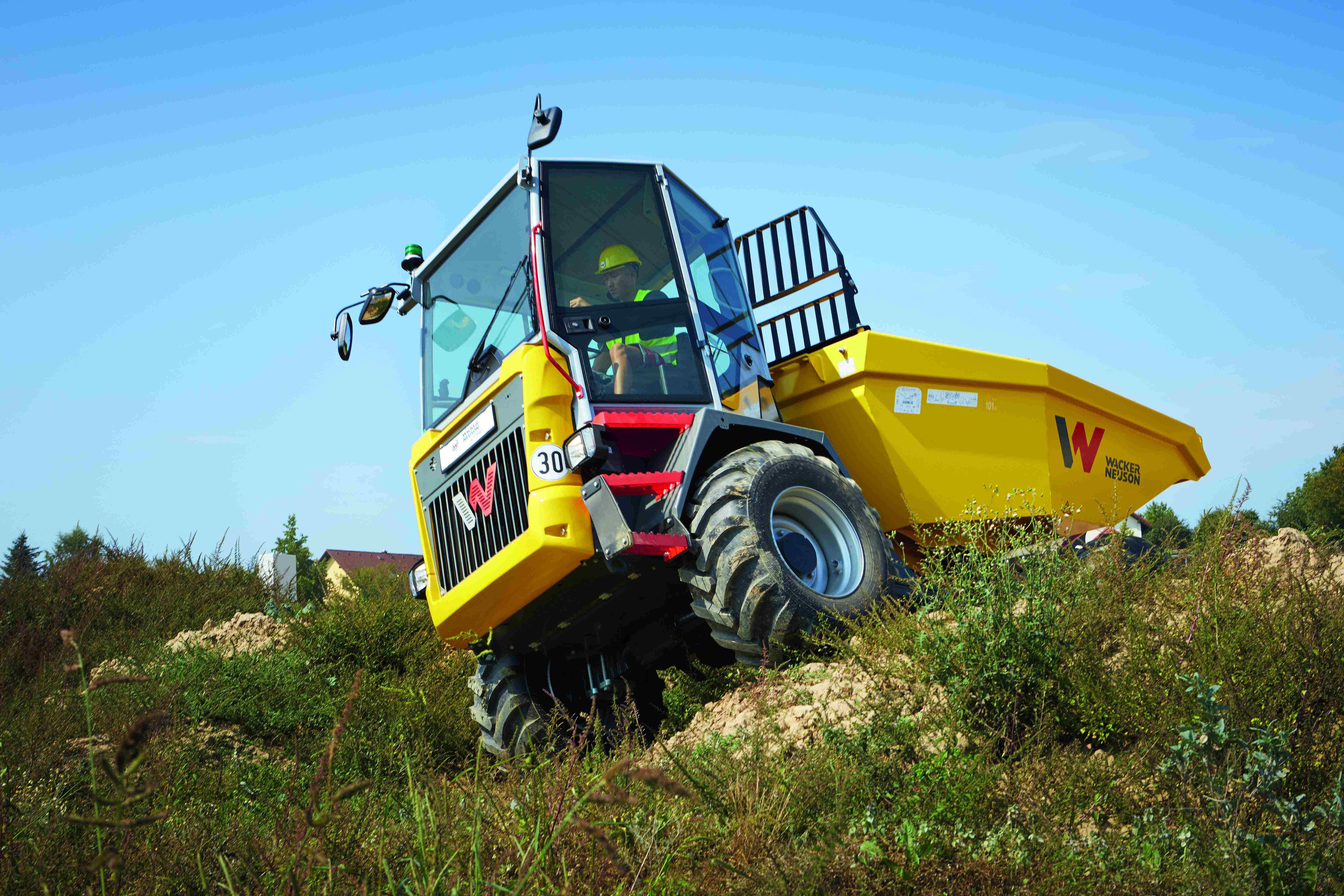Wacker Neuson dumper driving on uneven terrain with operator in cab during construction work