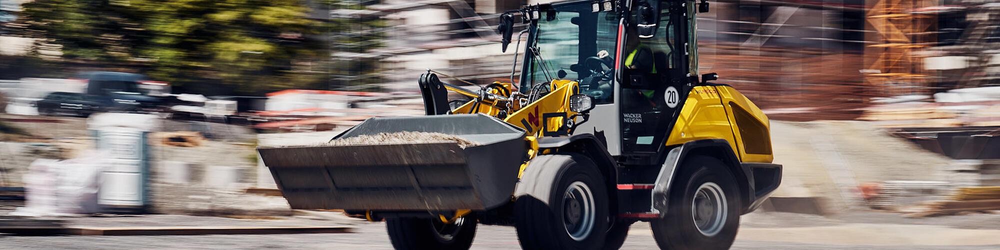 La pala gommata Wacker Neuson WL950p ad alte prestazioni mentre procede a tutta velocità in un cantiere.